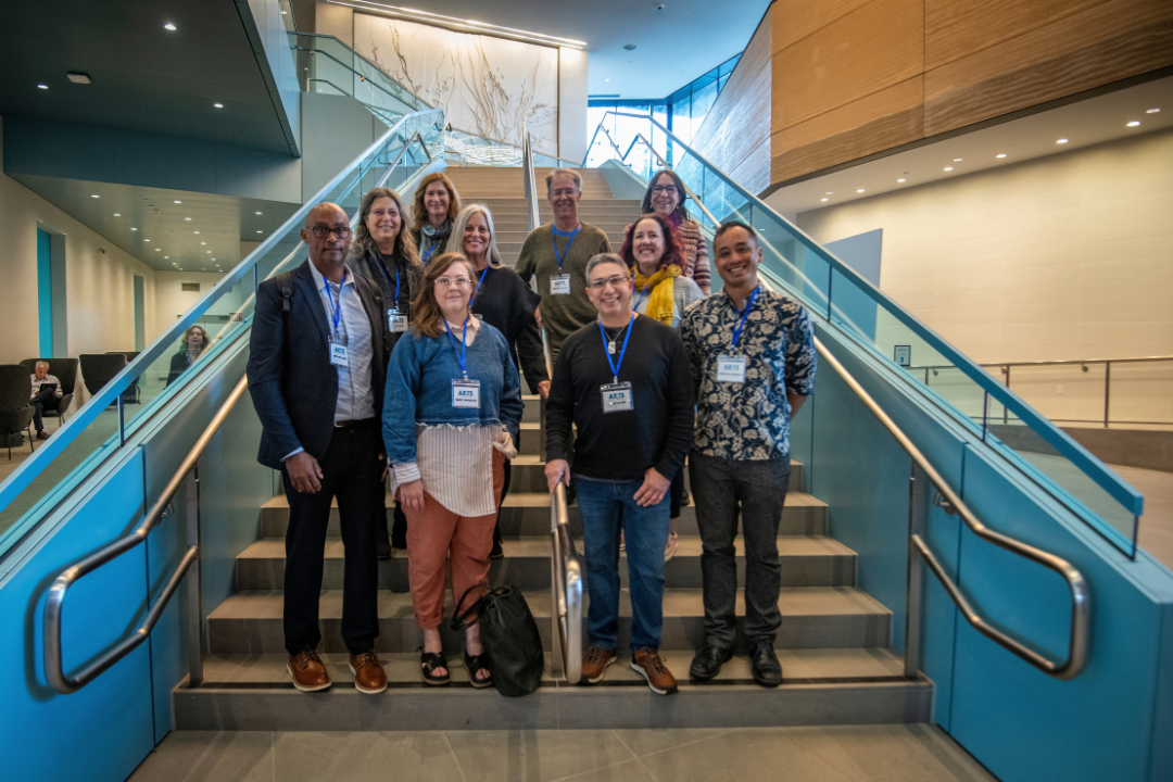 Ten members of the Arts in California Parks Advisory Committee pose for a photo at the bottom of a set of stairs.
